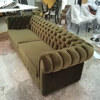 Brown deep-buttoned sofa photographed in the furniture workshop