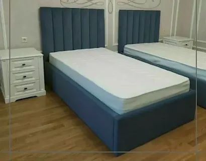 Blue upholstered bed with vertical-panel headboard